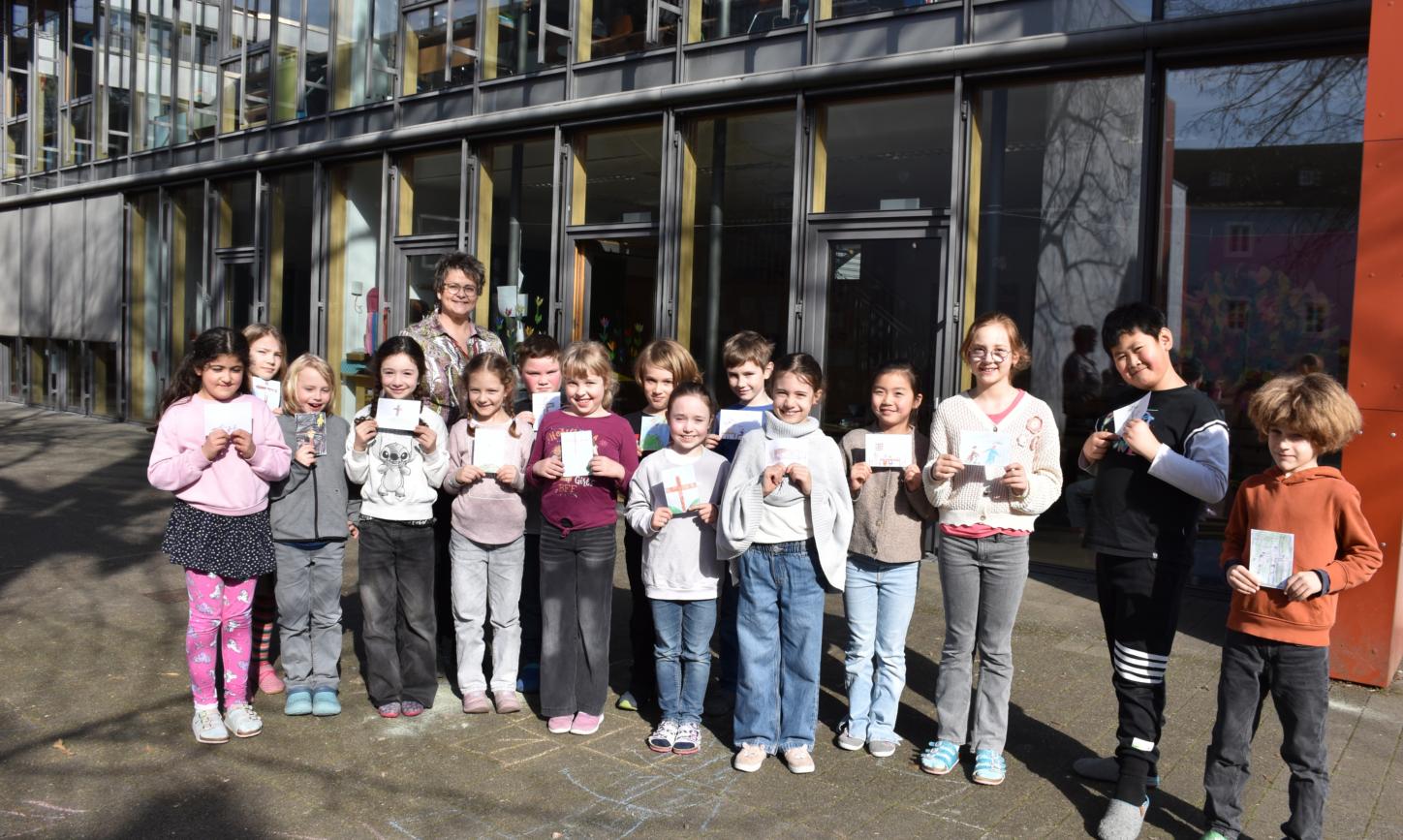 Eine Gruppe Grundschulkinder blickt lächelnd in die Kamera