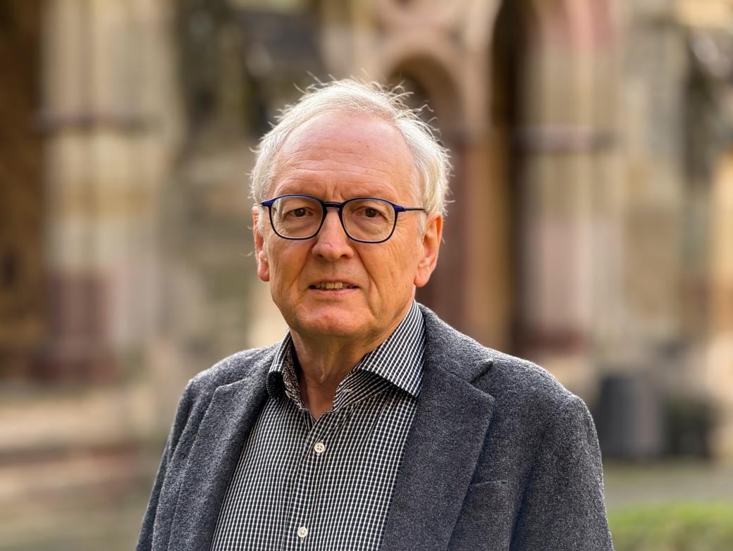 Ein älterer Herr mit Brille blickt in die Kamera