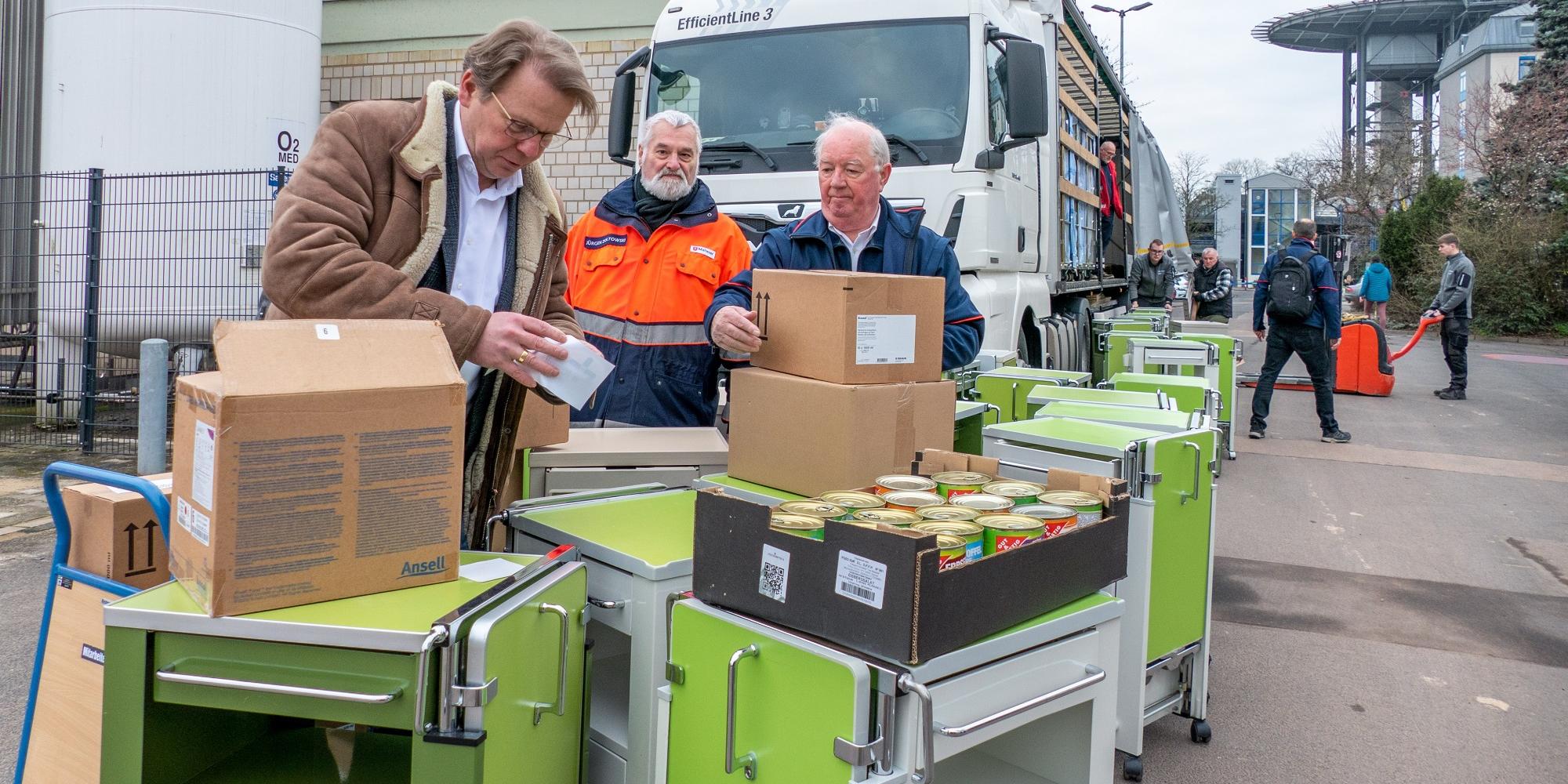 Markus Leineweber (links) und Ulrich Mathey (rechts) kontrollieren vor dem Verstauen die Waren. In der Mitte der Malteser Jürgen Zoltowski.