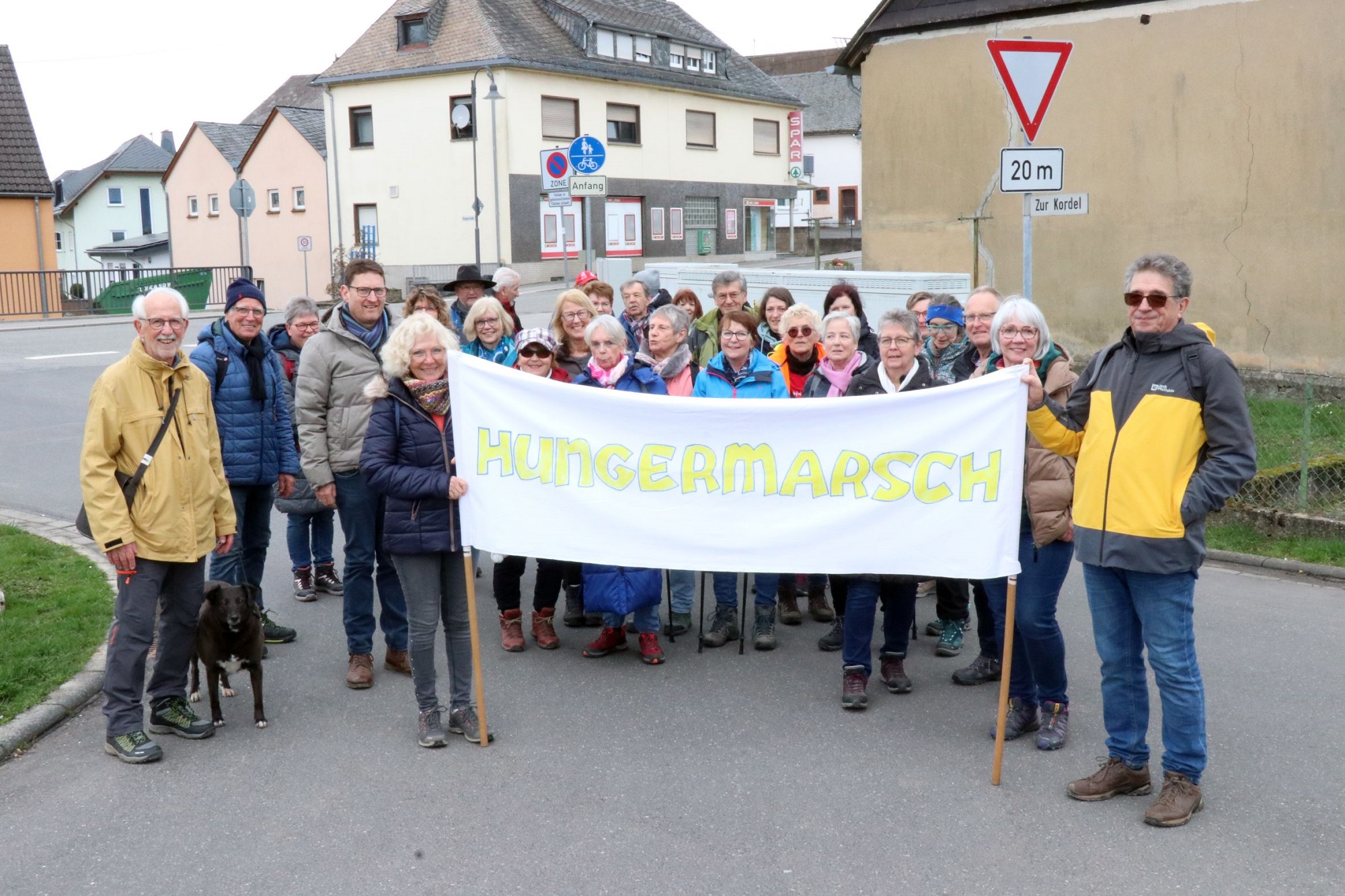 Teilnehmende mit Banner mit Aufschrift Hungermarsch.