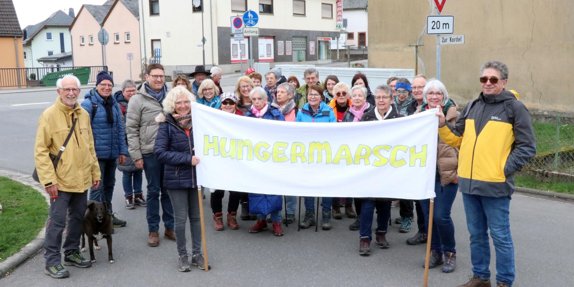 Teilnehmende mit Banner mit Aufschrift Hungermarsch. (c) Christoph Strouvelle Teilnehmende mit Banner mit Aufschrift Hungermarsch.