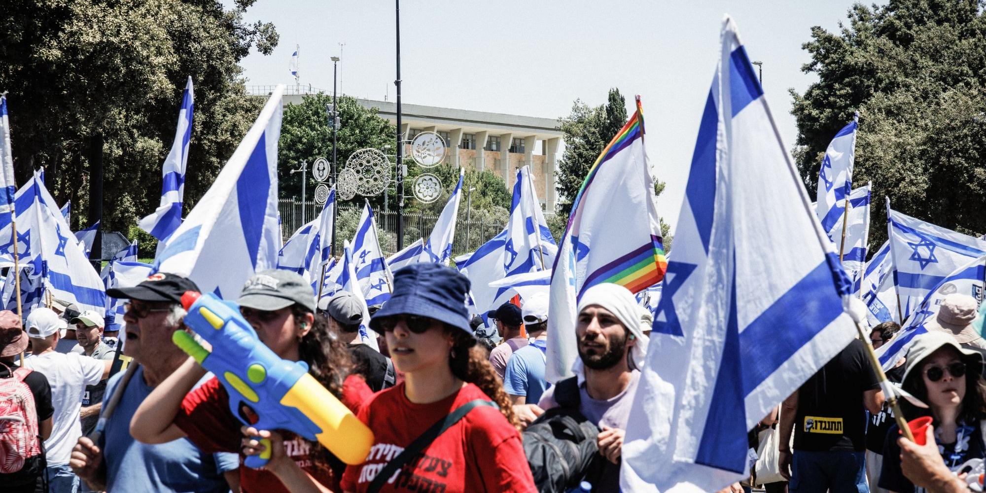 Menschen halten am 24. Juli israelische Flaggen hoch während einer Demonstration gegen die geplante Justizreform in Israel.