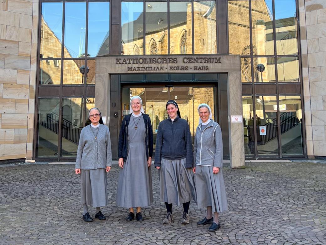 Schwester Maria, Schwester Marilen, Schwester Franja und Schwester Annette (von links) vor dem Katholischen Centrum in Dortmund. In den Fenstern spiegelt sich die Propsteikirche.