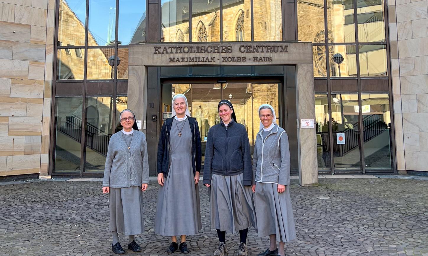 Schwester Maria, Schwester Marilen, Schwester Franja und Schwester Annette (von links) vor dem Katholischen Centrum in Dortmund. In den Fenstern spiegelt sich die Propsteikirche.