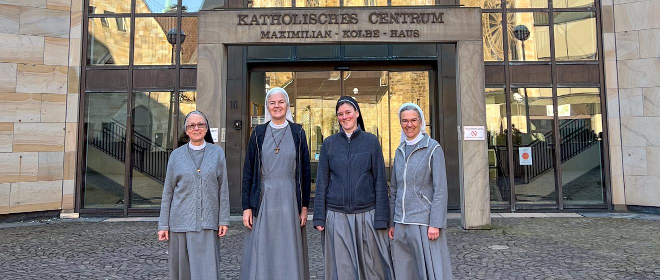 Schwester Maria, Schwester Marilen, Schwester Franja und Schwester Annette (von links) vor dem Katholischen Centrum in Dortmund. In den Fenstern spiegelt sich die Propsteikirche.