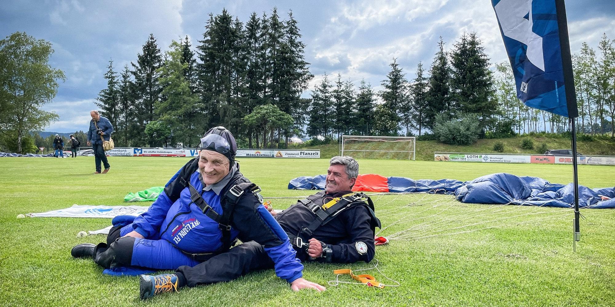 Pfarrer Huber (63, links) und ein Mitglied seines Teams nach der Fallschirmlandung am 22. Juni auf einer Wiese in Schwabbruck (c) Renzikowski/KNA Pfarrer Huber (63, links) und ein Mitglied seines Teams nach der Fallschirmlandung am 22. Juni auf einer Wiese in Schwabbruck