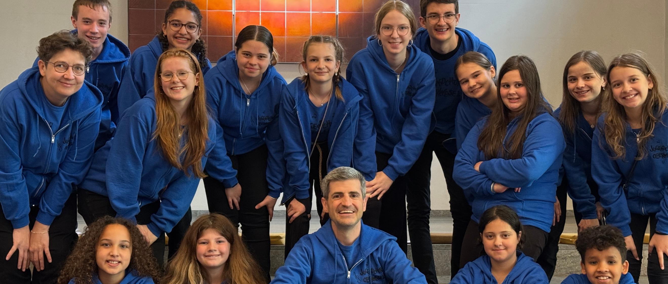 Mädchen und Jungen im Blauen Oberteil blicken lächelnd in die Kamera