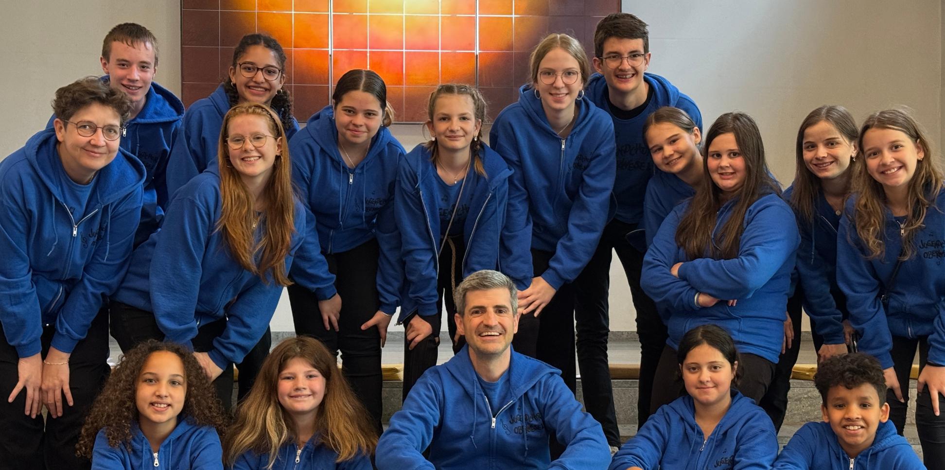 Mädchen und Jungen im Blauen Oberteil blicken lächelnd in die Kamera