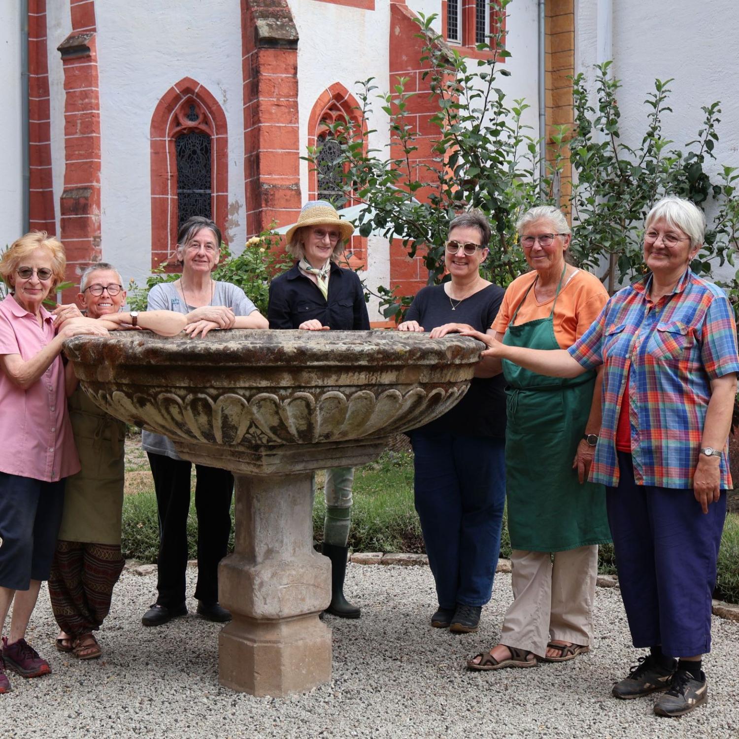 Eine Gruppe Frauen steht um ein großes Taufbecken