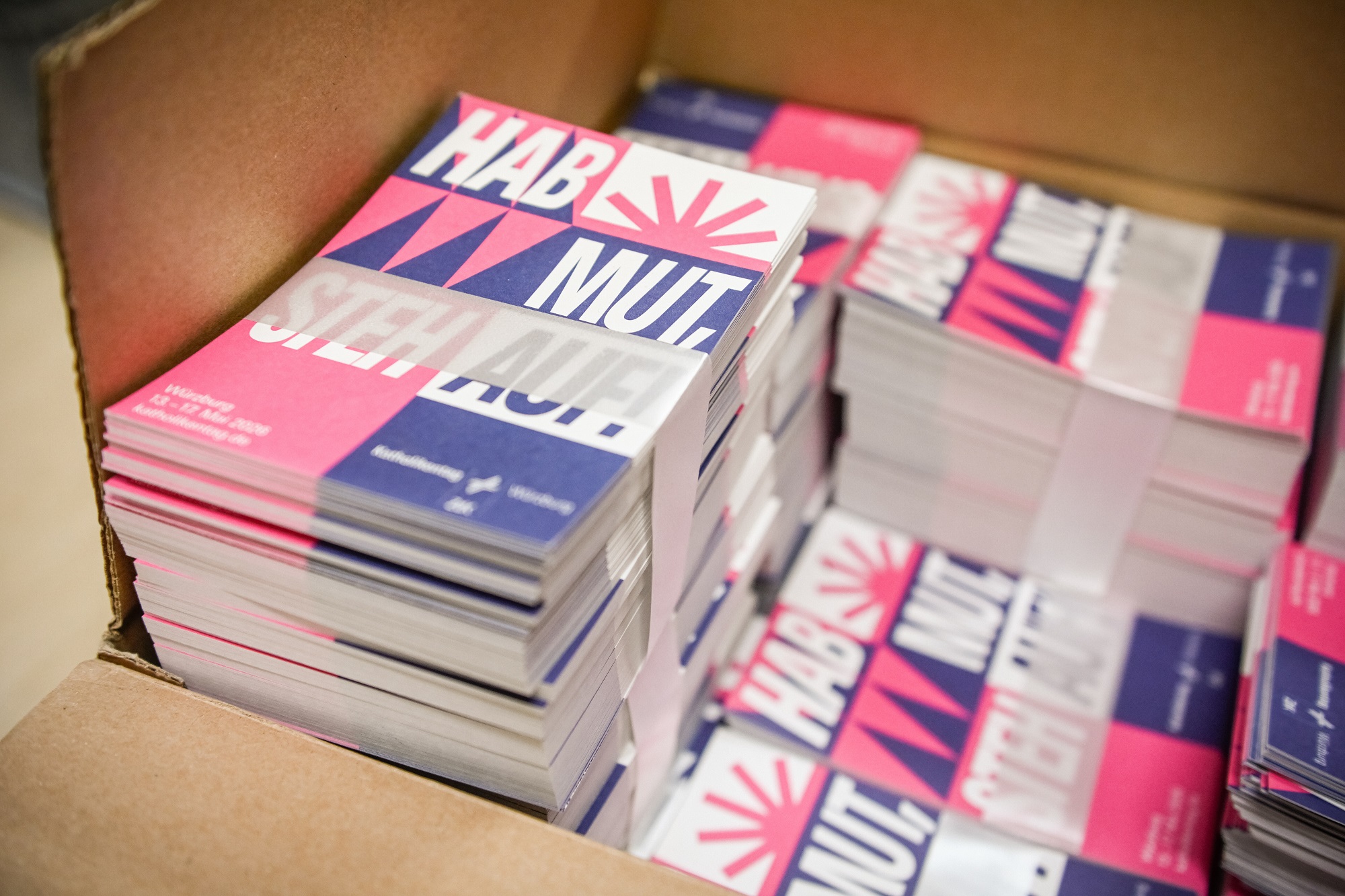 Karten mit dem Katholikentags-Leitspruch „Hab Mut, steh auf!“ in der Geschäftsstelle des Katholikentags in Würzburg.