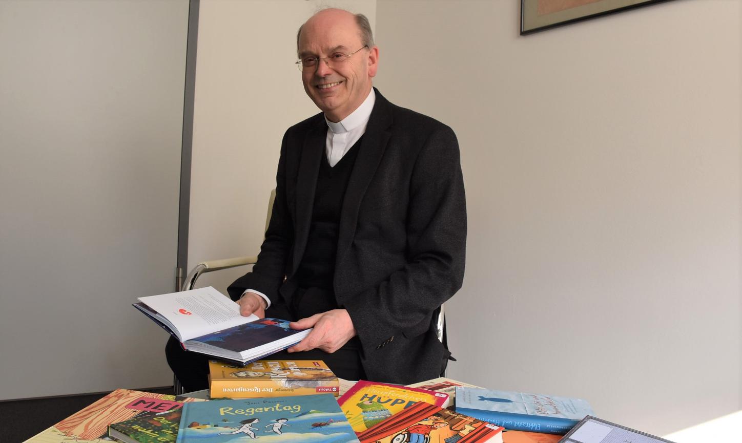 Die 15 Bücher der Empfehlungsliste stellt Weihbischof Robert Brahm in seinem Büro vor