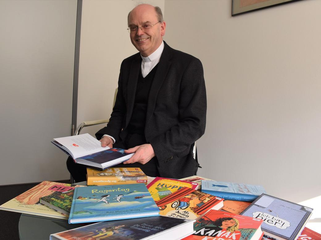 Die 15 Bücher der Empfehlungsliste stellt Weihbischof Robert Brahm in seinem Büro vor