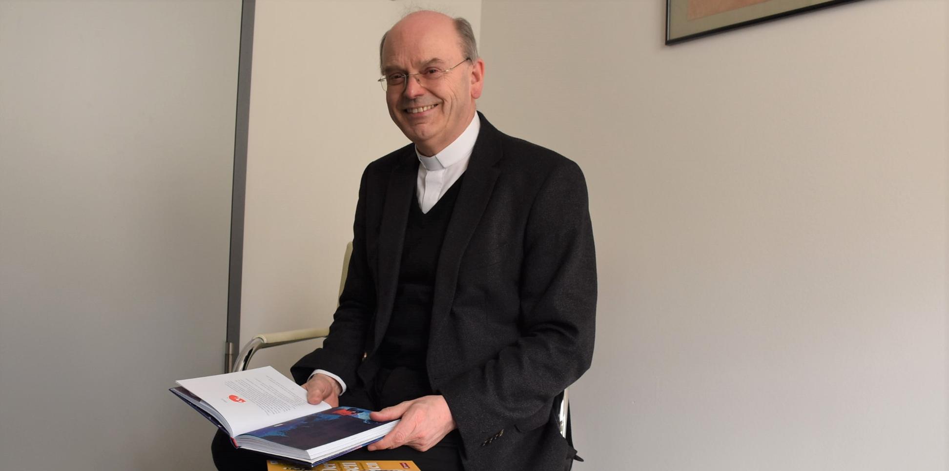 Die 15 Bücher der Empfehlungsliste stellt Weihbischof Robert Brahm in seinem Büro vor
