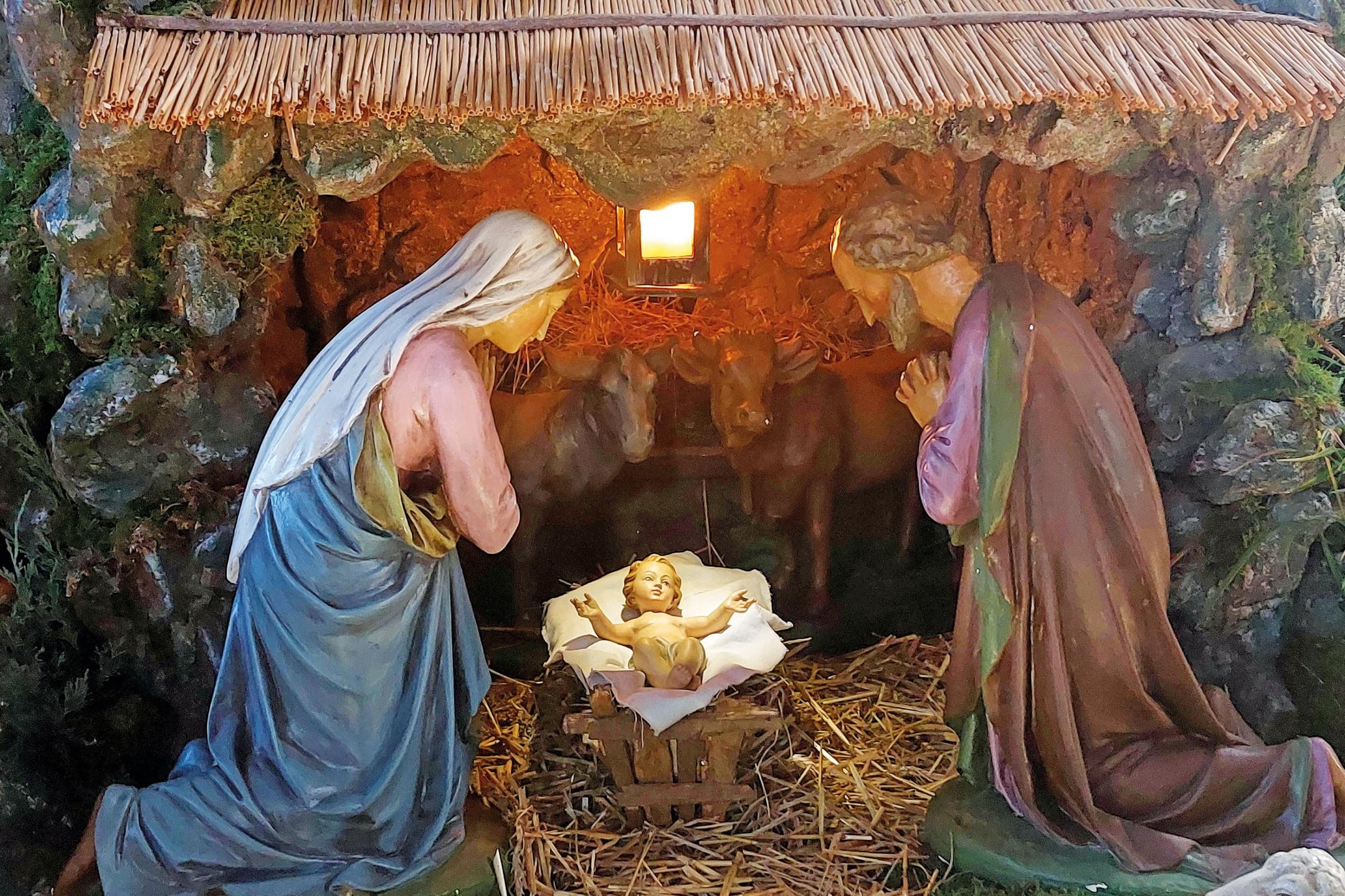 Weihnachtskrippe mit Maria und Josef. Sie knien vor dem Jesuskind, denn Gott wird selbst Mensch, kommt als Kind zur Welt.