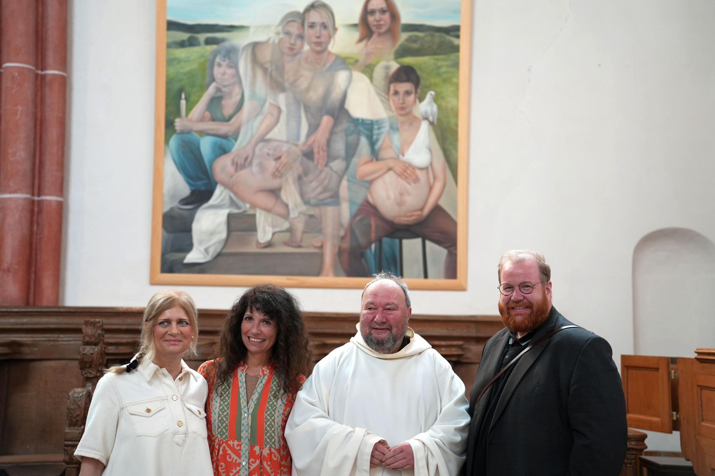 Kunsthistorikerin Dr. Ute Bopp-Schumacher, Künstlerin Silke Aurora, Pfarrer Klaus Bender und Kulturdezernent Markus Nöhl (von links) vor dem Bild „Ich bin Maria“ an der Nordwand der Stiftskirche in Kyllburg.