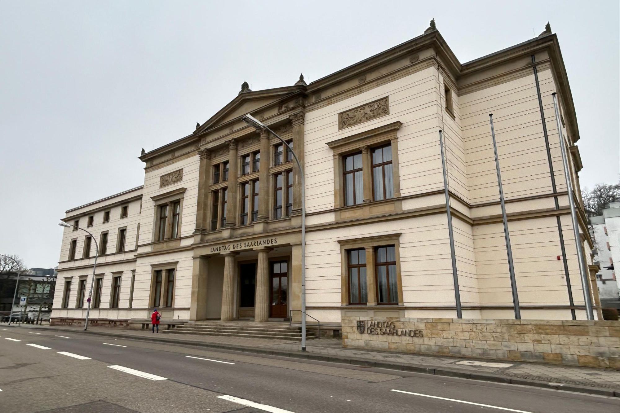 Ein beige-braunes Gebäude mit der Aufschrift Landtag des Saarlandes