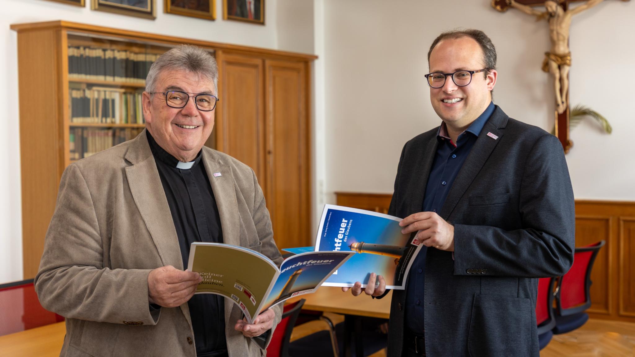 Die Autoren : der Generalsekretär des Bonifatiuswerks, Monsignore Austen (links), und Daniel Born, Referent im Bereich „Missionarische und diakonische Pastoral“ blättern in  der neuen Broschüre „Leuchtfeuer des Glaubens“.