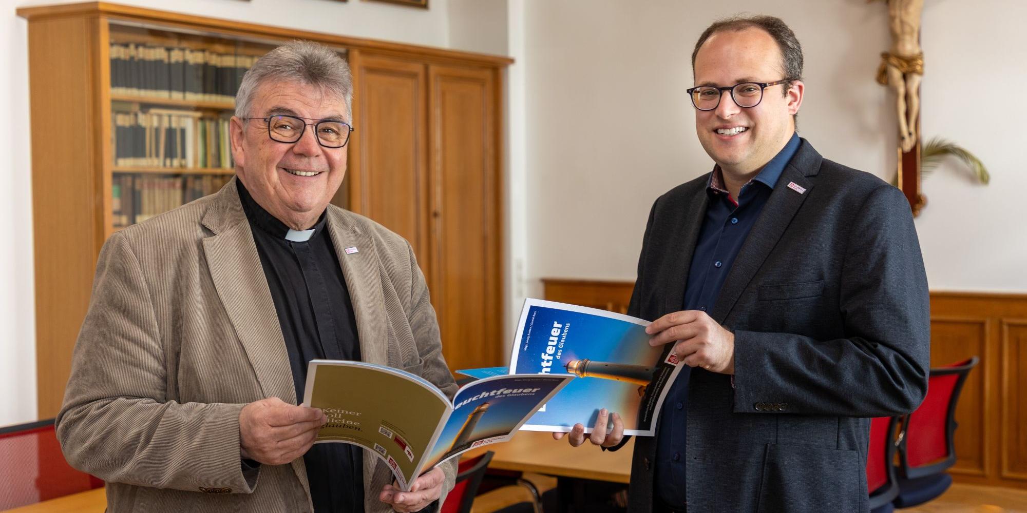 Die Autoren : der Generalsekretär des Bonifatiuswerks, Monsignore Austen (links), und Daniel Born, Referent im Bereich „Missionarische und diakonische Pastoral“ blättern in  der neuen Broschüre „Leuchtfeuer des Glaubens“.