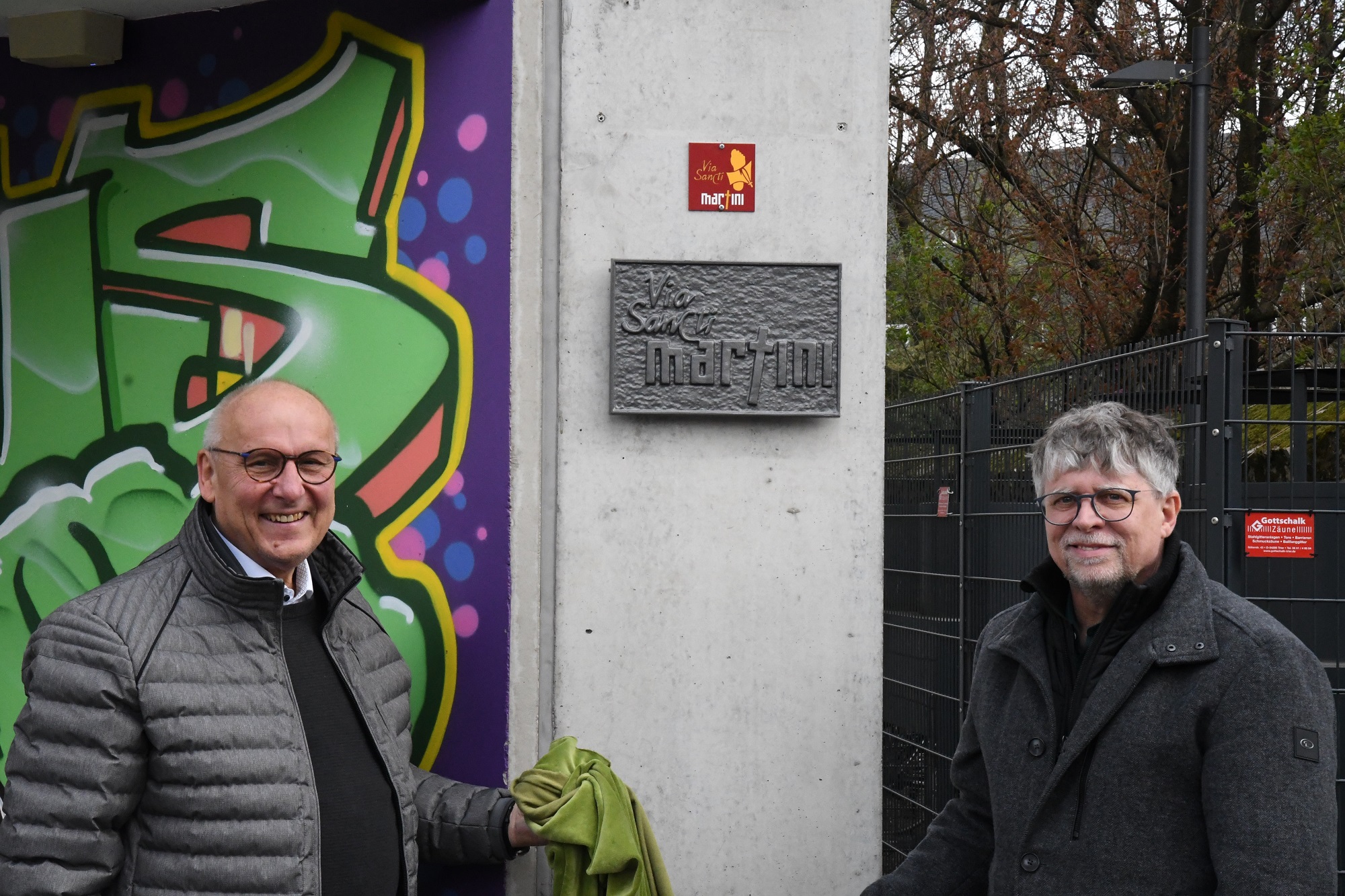 Horst Drach (links) und Andreas Wagner präsentieren die frisch enthüllte Wegmarke und die Plakette zum Martinusweg.