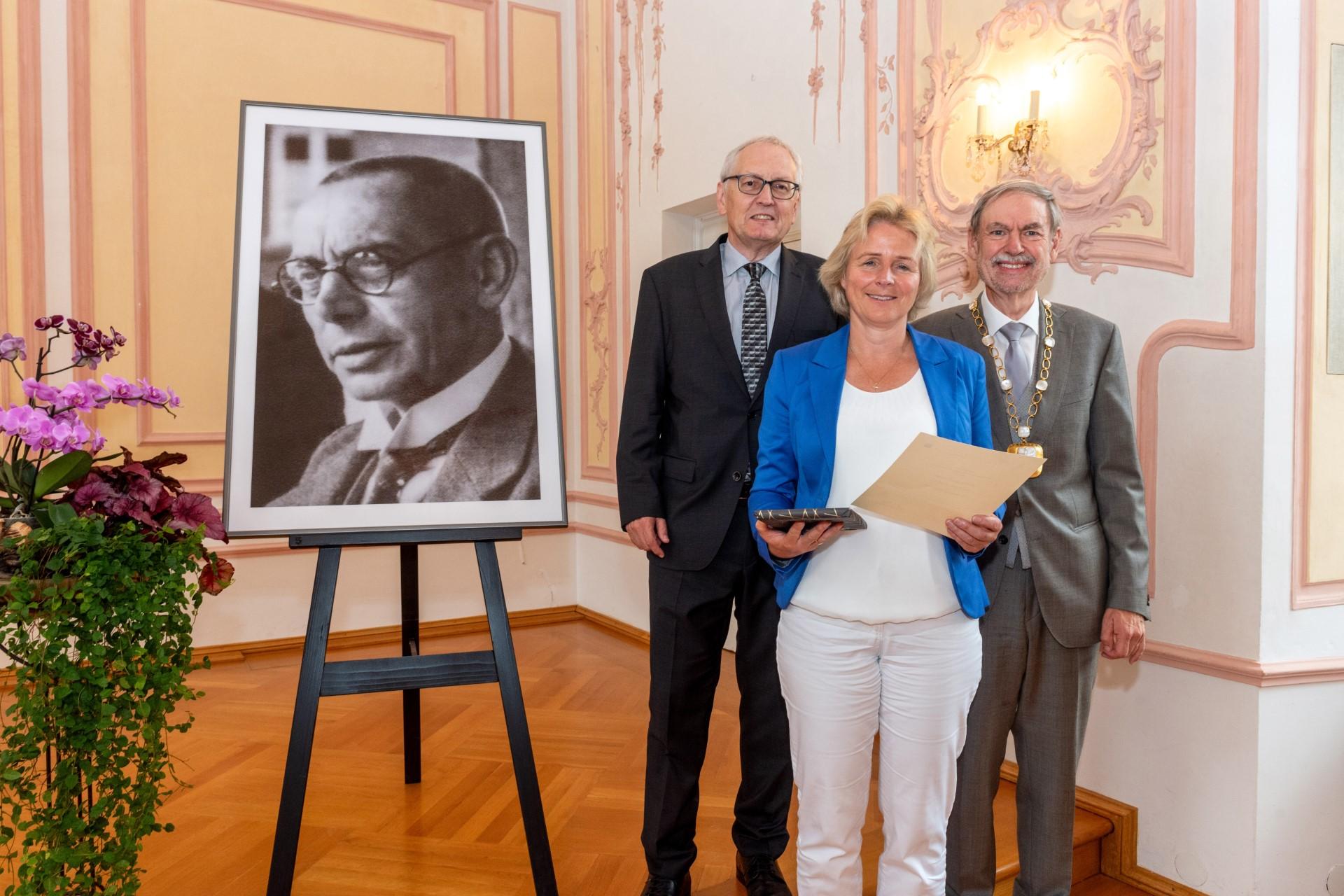 Dr. Hermann Groß (links), Präsident der Peter-Wust-Gesellschaft, und Professor Walter Andreas Euler, Rektor der Theologischen Fakultät Trier, gratulieren Schwester Melanie Wolfers zum Peter-Wust-Preis.