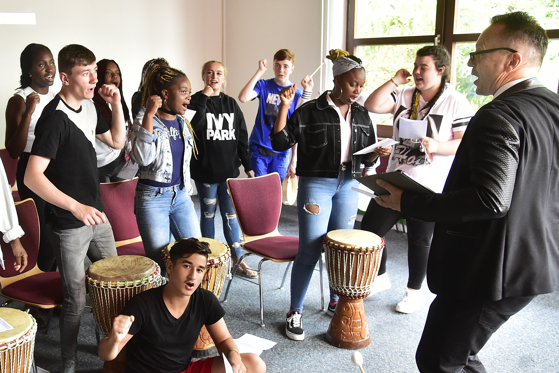 Schüler trommeln und tanzen.