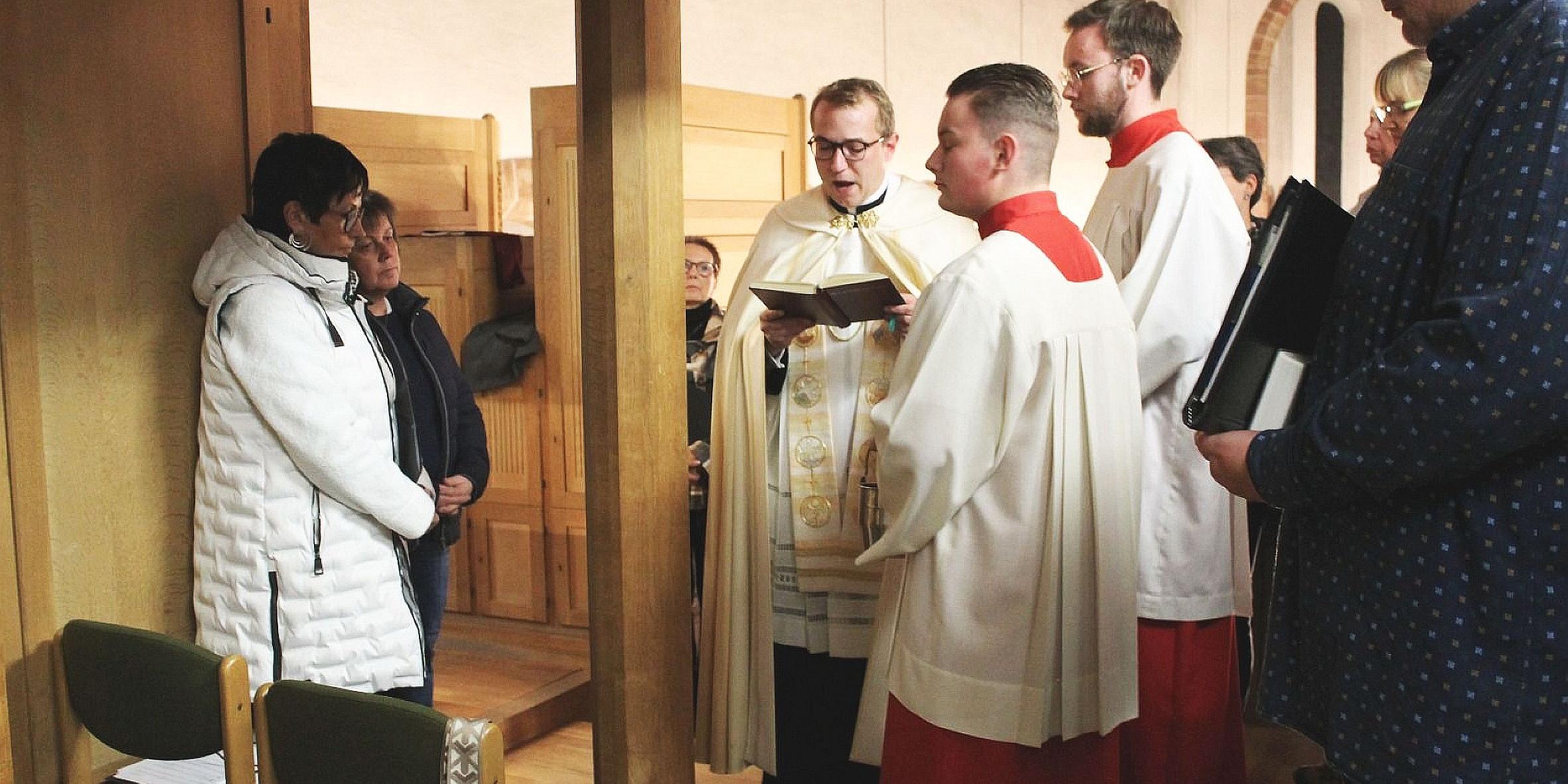 Menschen stehen an einer Orgel, die von einem Priester gesegnet wird
