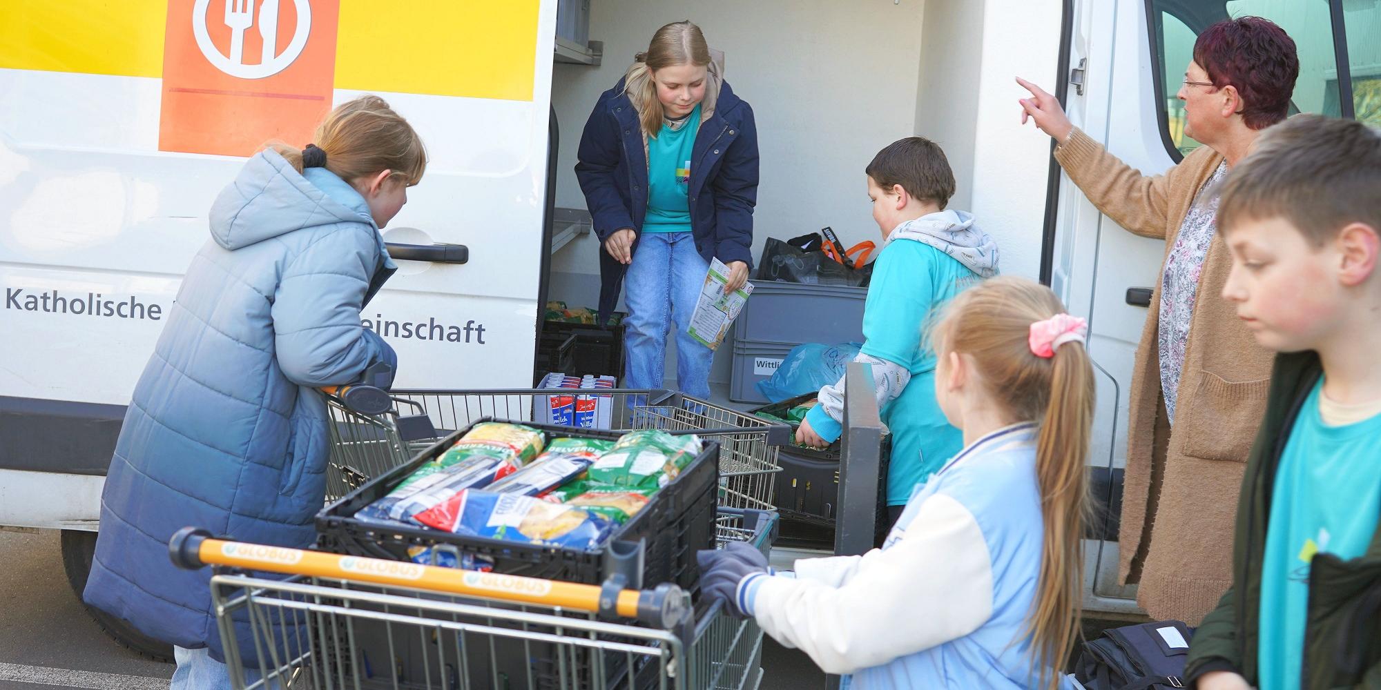 Schülerinnen und Schüler aus Wittlich laden gesammelte Lebensmittel in den „Tafel“-Transporter.