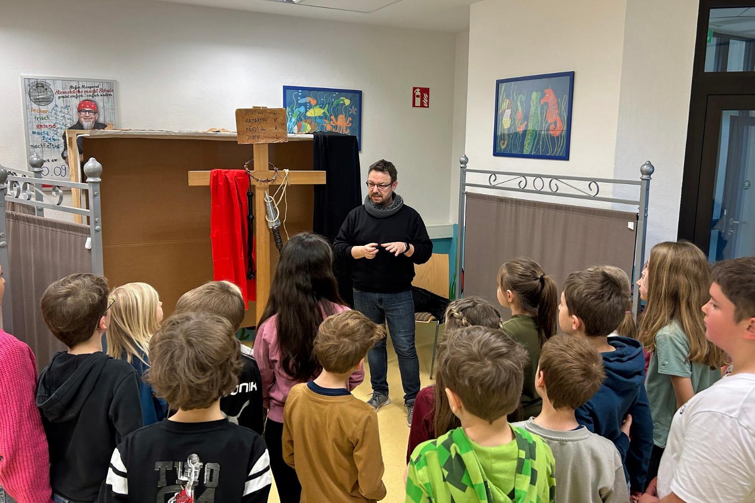Gemeindereferent Peter Holz spricht mit der Klasse über die Kreuzigungsszene.