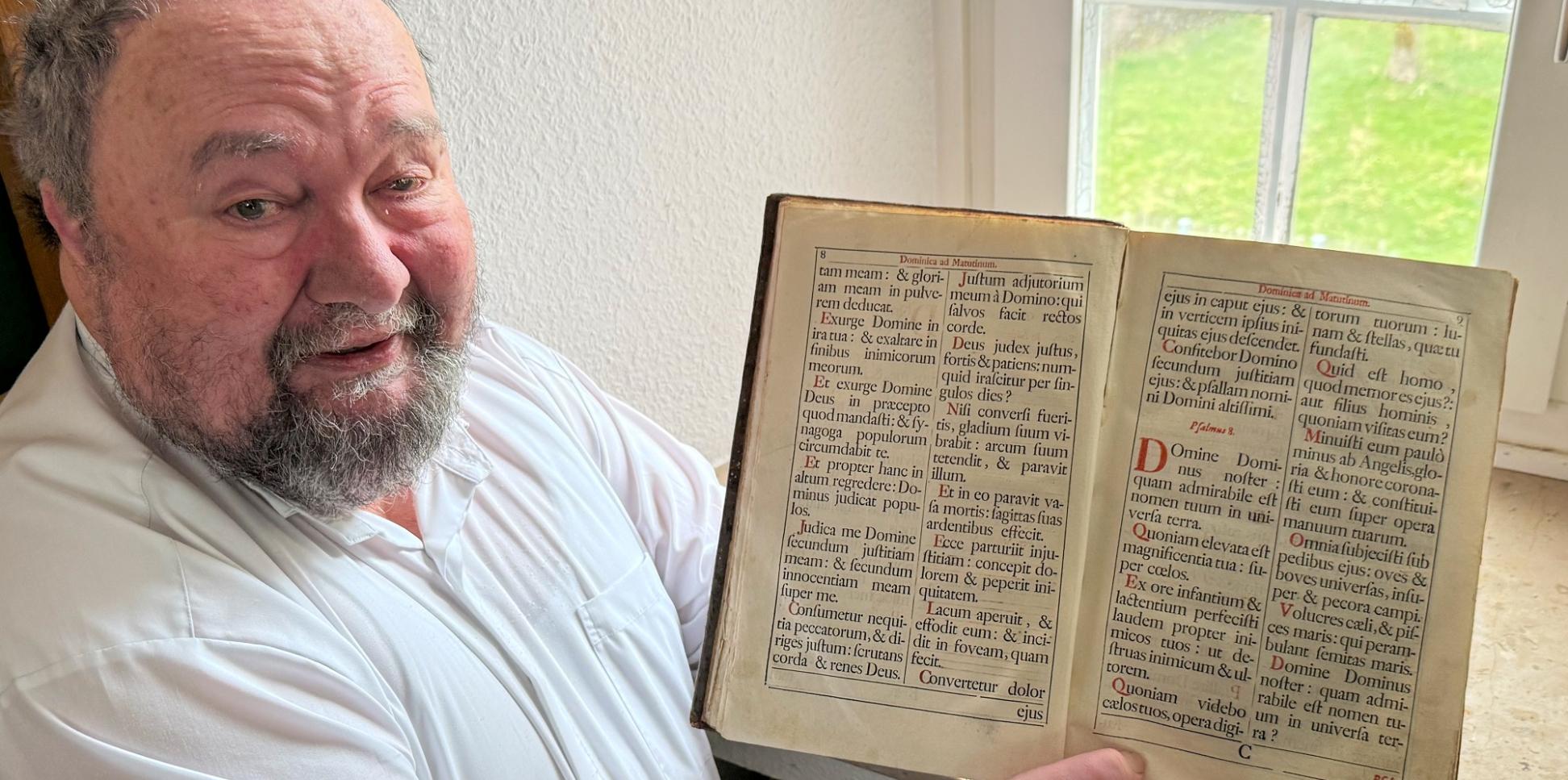 Pastor Klaus Bender zeigt ein altes Chorbuch.