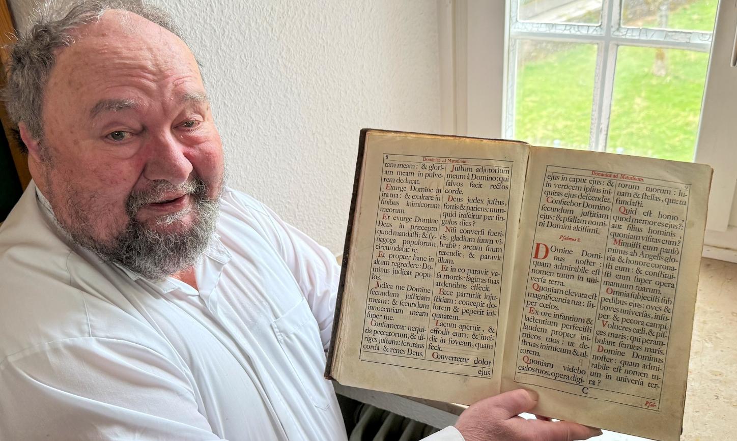 Pastor Klaus Bender zeigt ein altes Chorbuch.