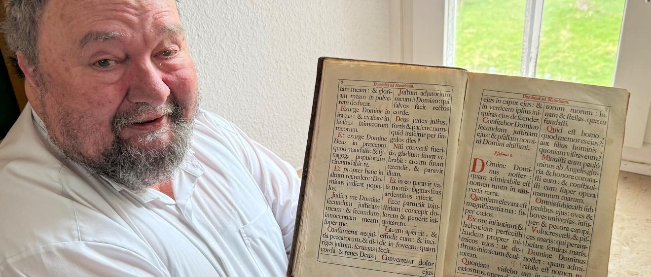 Pastor Klaus Bender zeigt ein altes Chorbuch.
