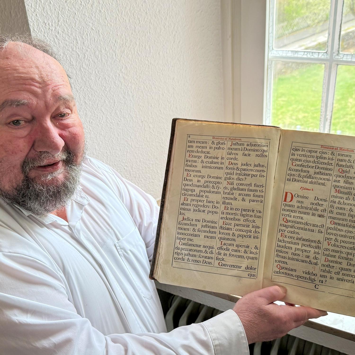 Pastor Klaus Bender zeigt ein altes Chorbuch.
