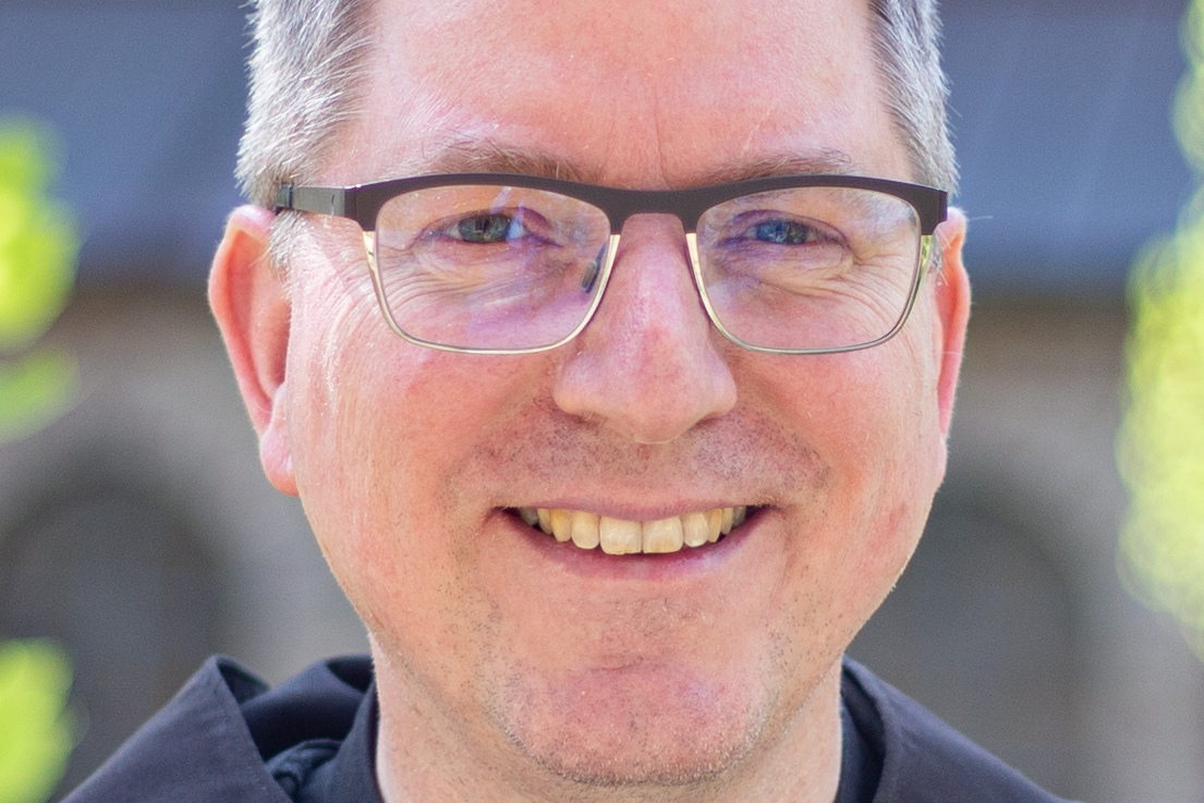 Ein Mann mit Brille lächelt in die Kamera