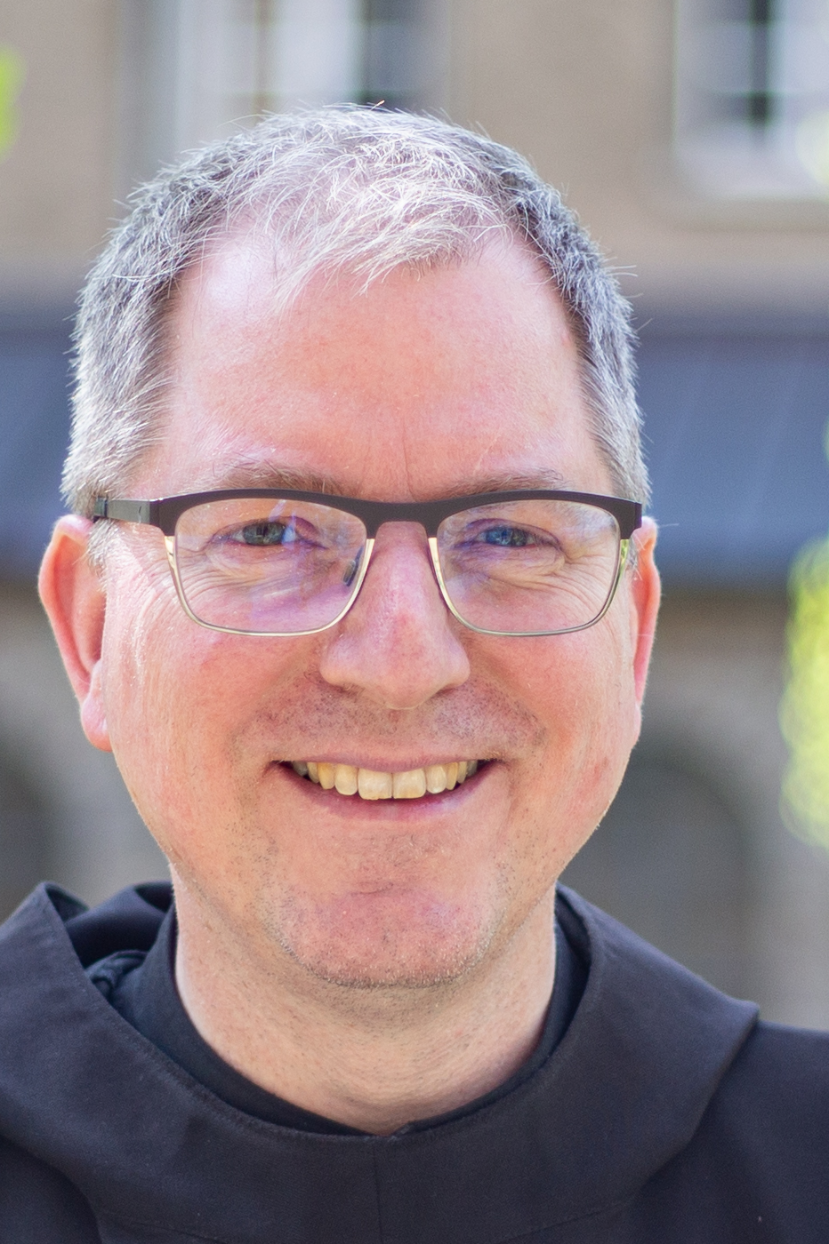 Ein Mann mit Brille lächelt in die Kamera