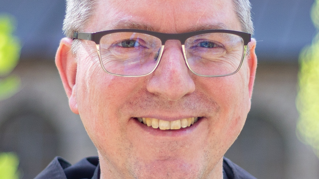 Ein Mann mit Brille lächelt in die Kamera