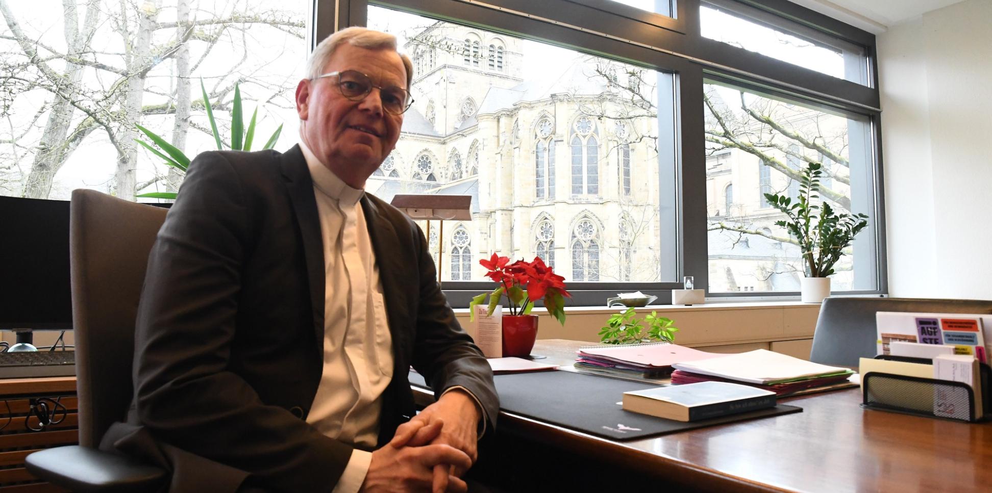 Generalvikar Dr. Ulrich Graf von Plettenberg an seinem Schreibtisch mit Blick auf  Dom, Liebfrauen und Bischofsgarten.