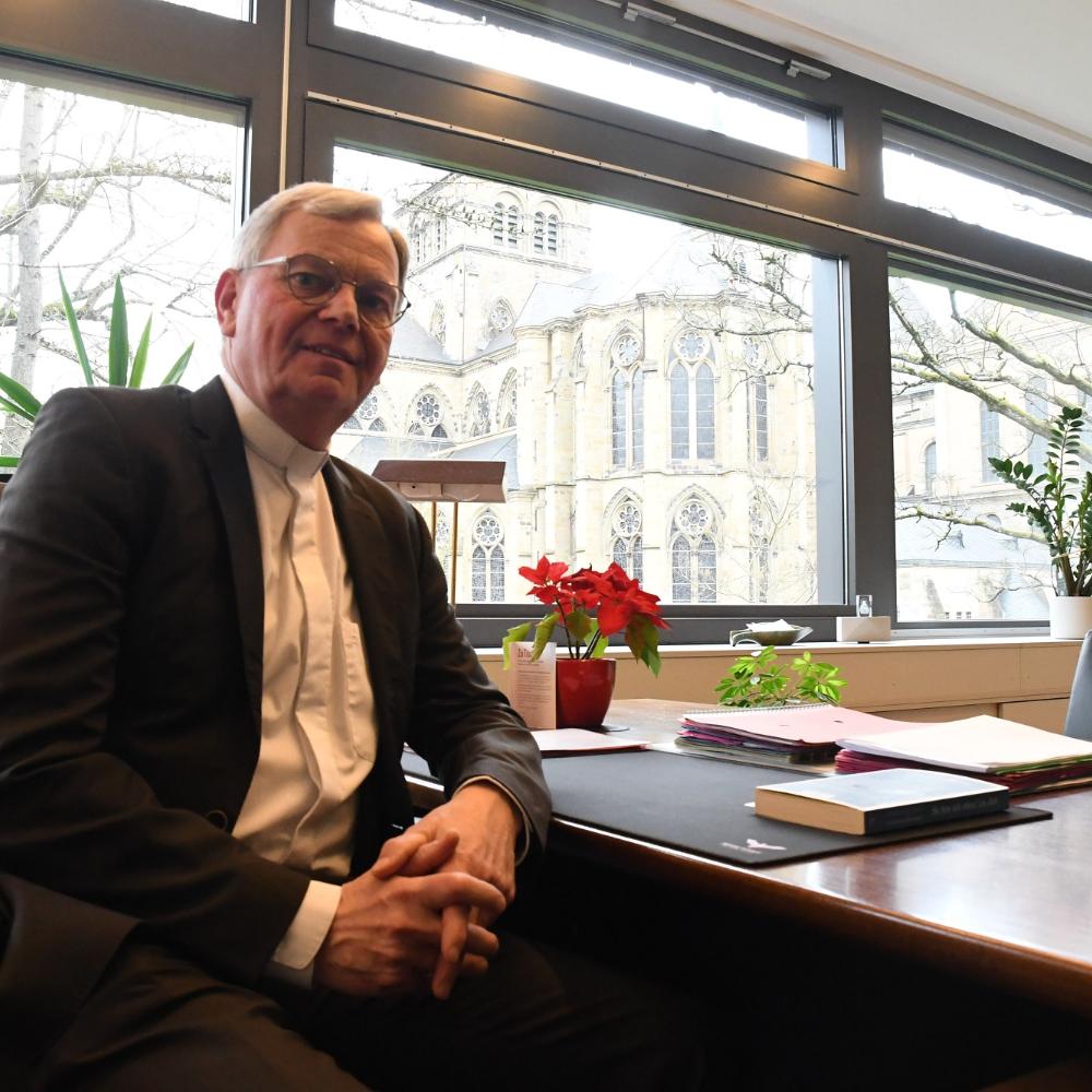 Generalvikar Dr. Ulrich Graf von Plettenberg an seinem Schreibtisch mit Blick auf  Dom, Liebfrauen und Bischofsgarten.