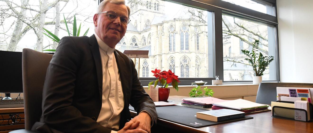 Generalvikar Dr. Ulrich Graf von Plettenberg an seinem Schreibtisch mit Blick auf  Dom, Liebfrauen und Bischofsgarten.