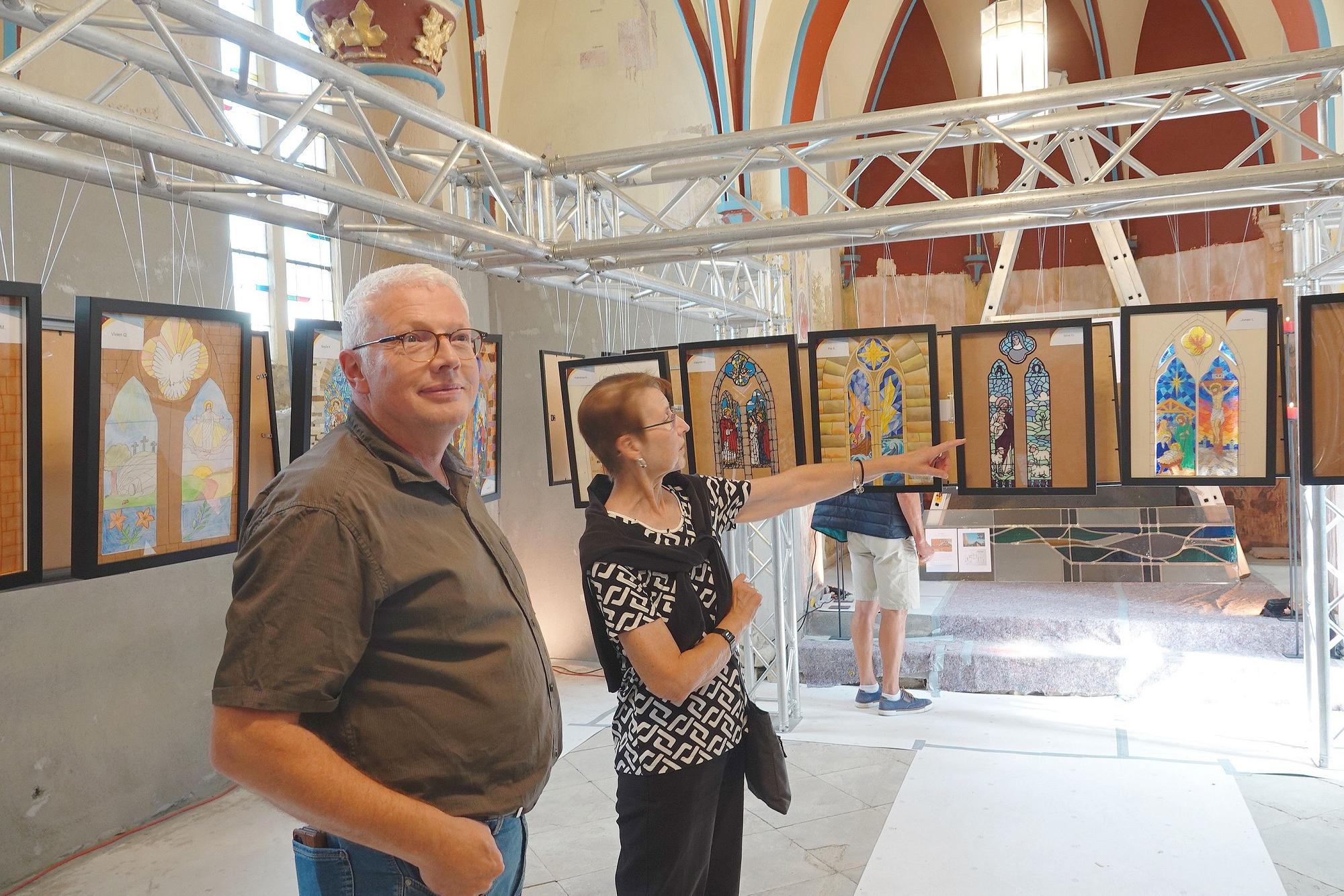 Im noch immer nicht flutsanierten „Hemmessener Dom“ schaut sich Markus Hartmann zusammen mit  einer Besucherin die Ideen der Zwölftklässler zur Fenstergestaltung an.