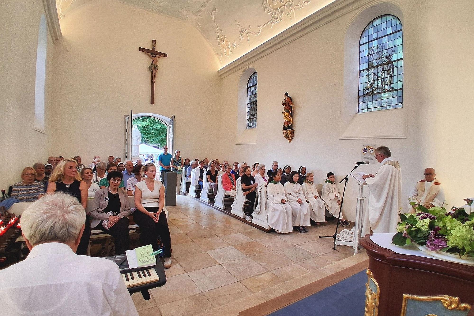 Innenansicht der voll besetzten Kapelle vom Altar aus.