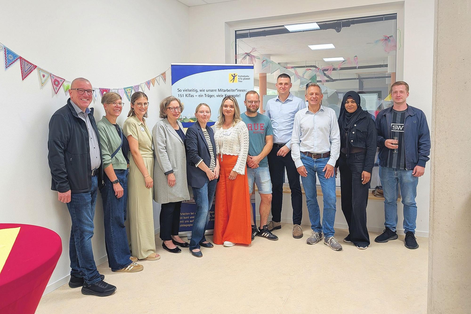 Gruppenbild der Vertreterinnen  und Vertreter von Bistum, Trägergesellschaft, KiTa, Stadt, Investmentfirma und Elternschaft bei der Einweihungsfeier.