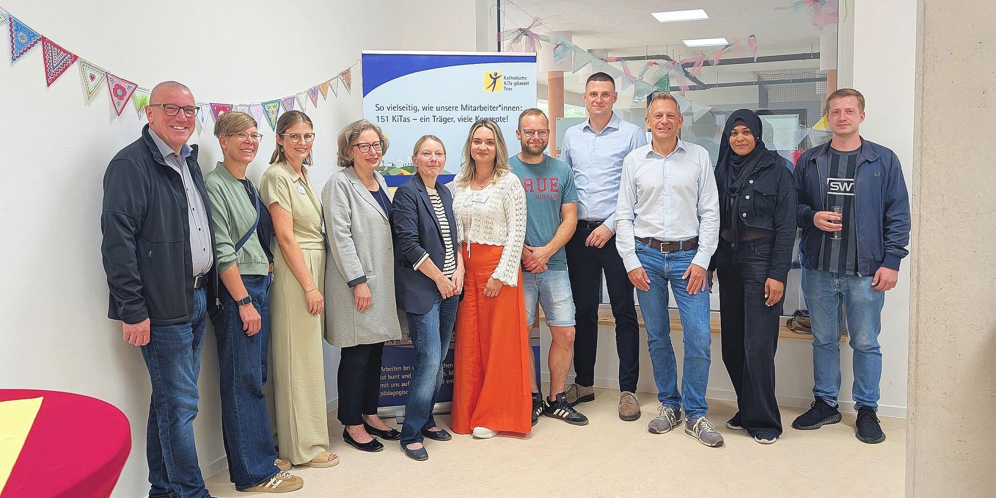 Gruppenbild der Vertreterinnen  und Vertreter von Bistum, Trägergesellschaft, KiTa, Stadt, Investmentfirma und Elternschaft bei der Einweihungsfeier.