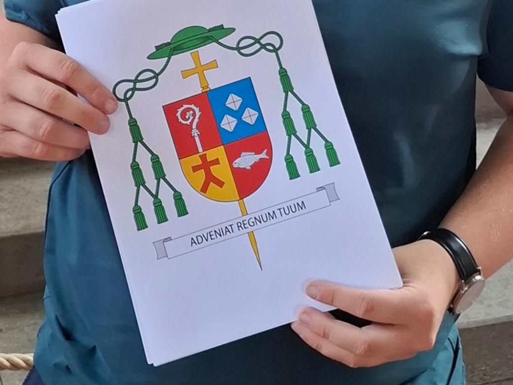 Lukas Böck präsentiert das von ihm gestaltete Wappen.