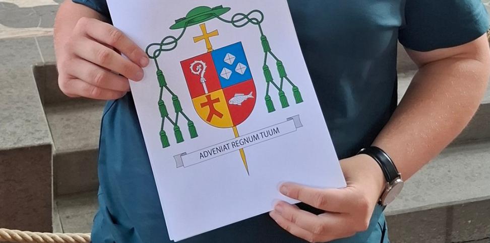 Lukas Böck präsentiert das von ihm gestaltete Wappen.