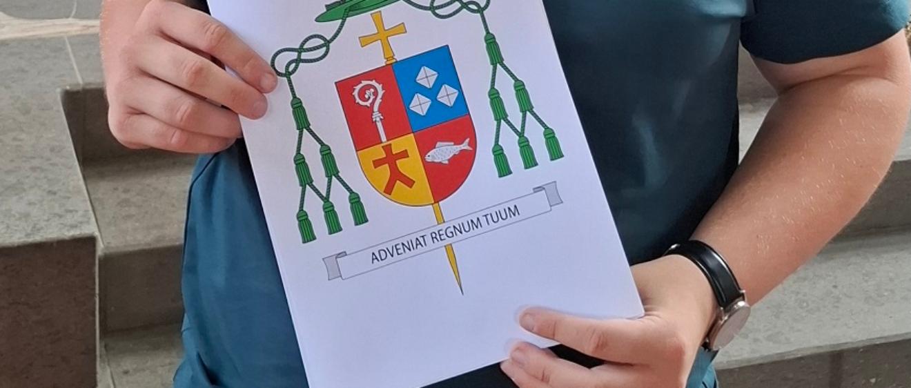 Lukas Böck präsentiert das von ihm gestaltete Wappen.