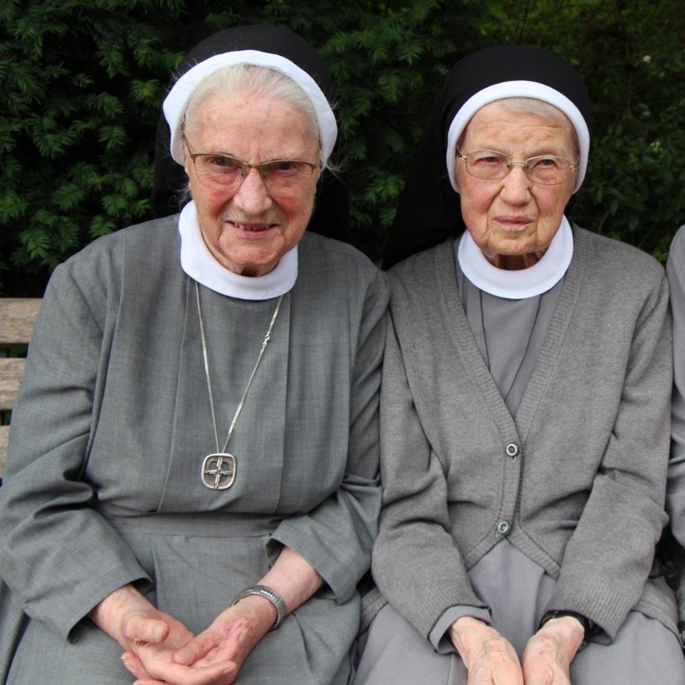 Die Katharinenschwestern Magdalena, Cäcilia und Caritina (von links) sitzen auf einer Bank.