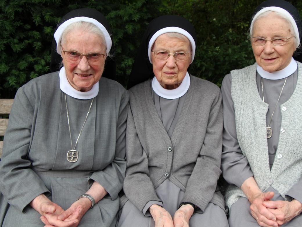 Die Katharinenschwestern Magdalena, Cäcilia und Caritina (von links) sitzen auf einer Bank.