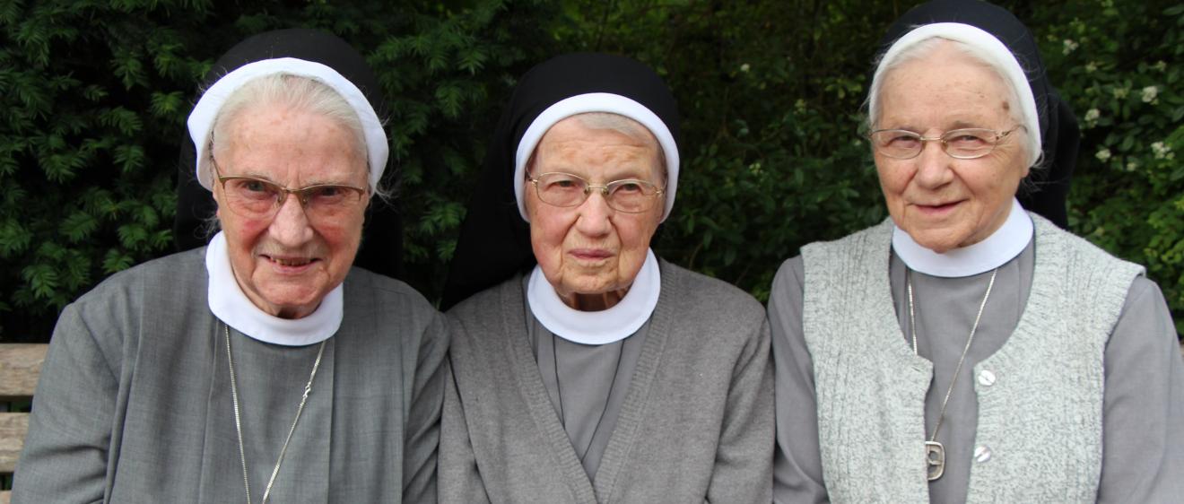 Die Katharinenschwestern Magdalena, Cäcilia und Caritina (von links) sitzen auf einer Bank.