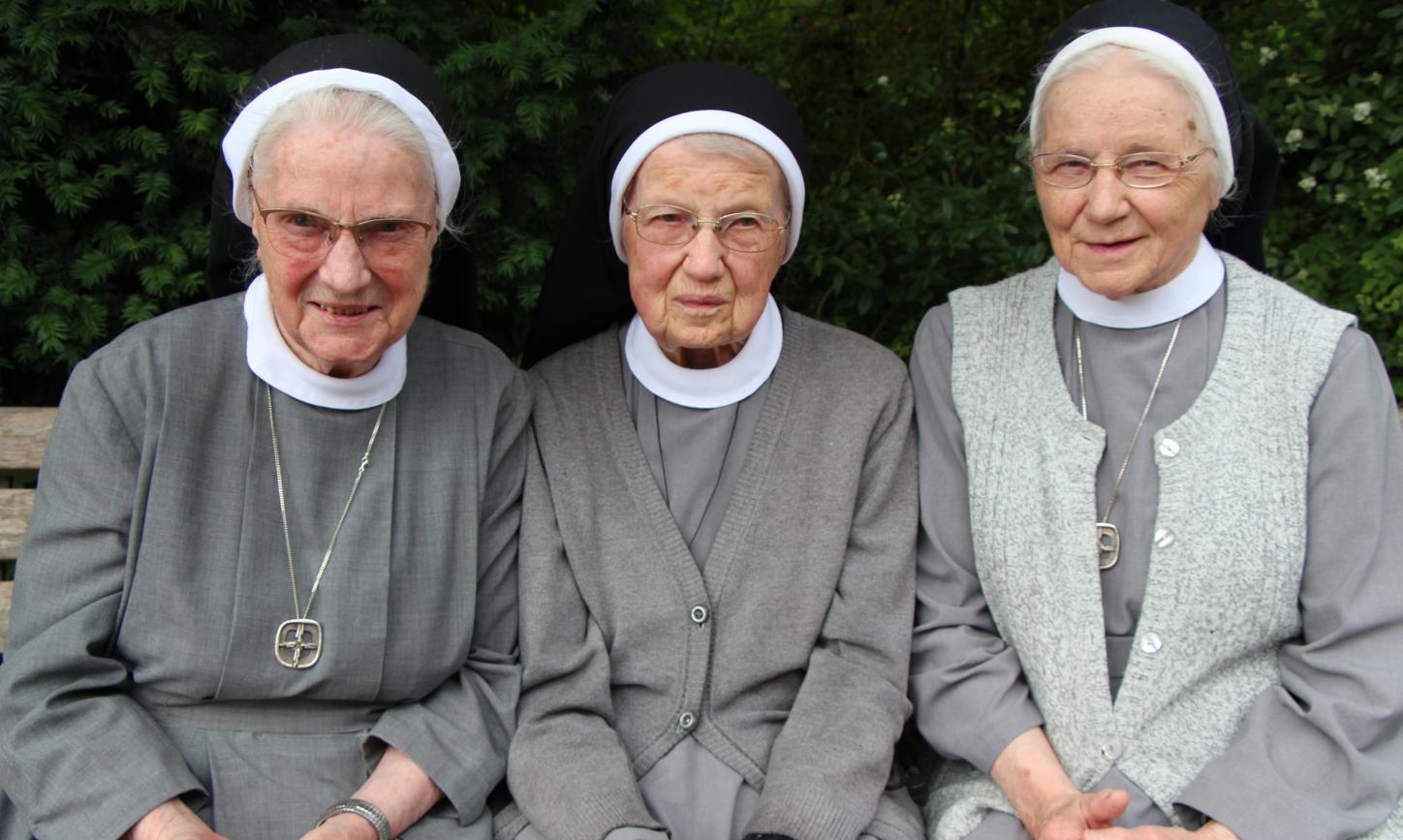 Die Katharinenschwestern Magdalena, Cäcilia und Caritina (von links) sitzen auf einer Bank.