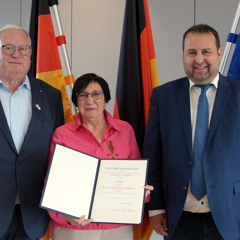 Rita Monz mit dem saarländischen Minister Magnus Jung (rechts) und Stefan Löw, dem Ortsvorsteher von Wiesbach.